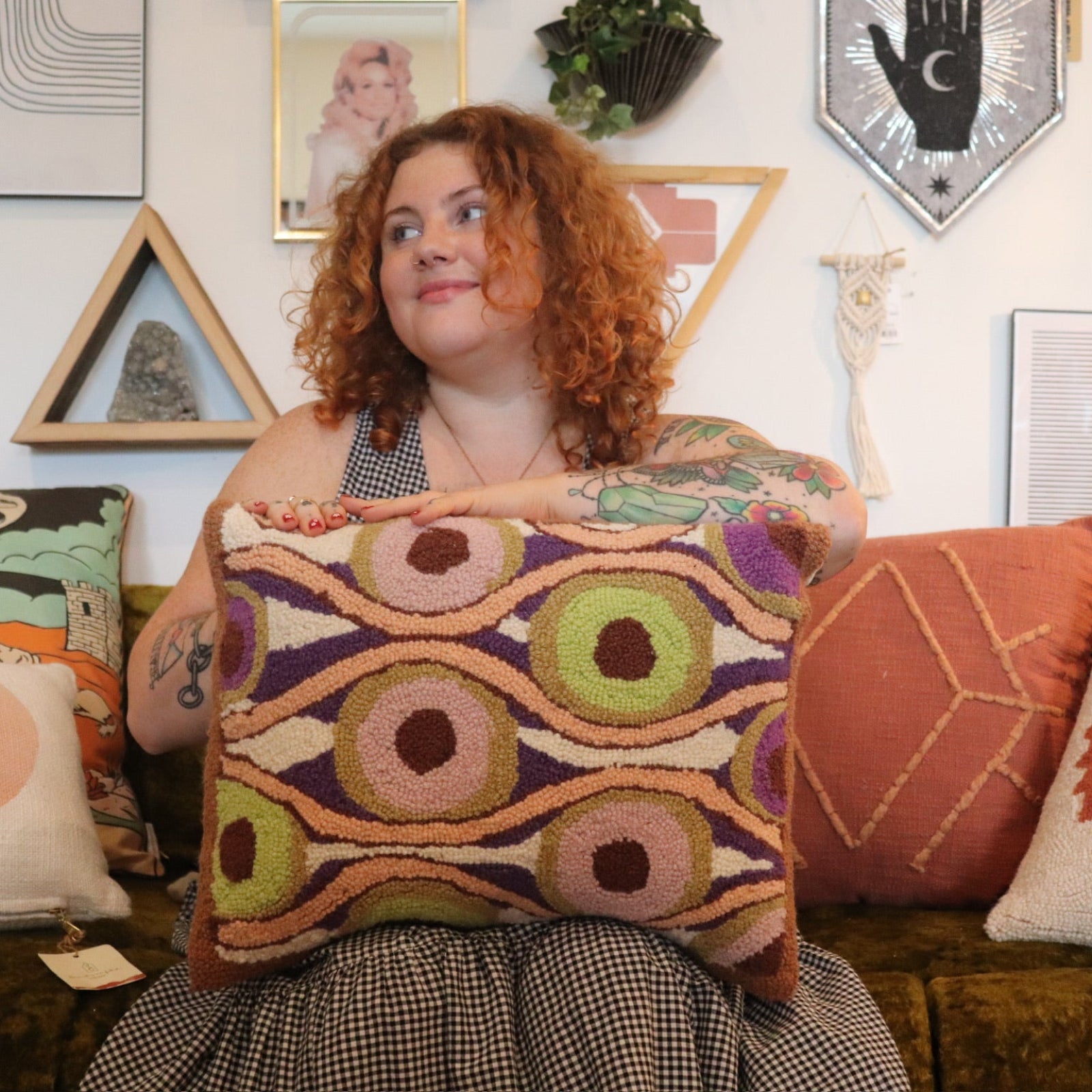 A woman holding the Snack Wool Hook Pillow.