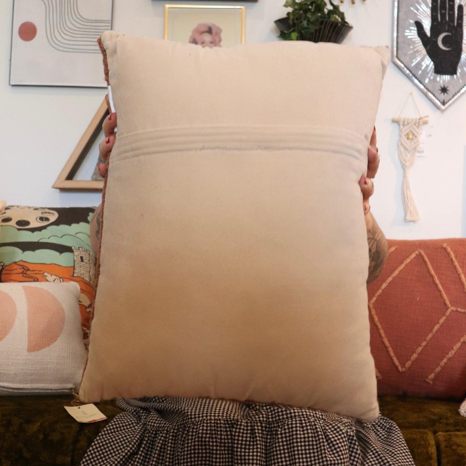 A woman holding the Snack Wool Hook Pillow.