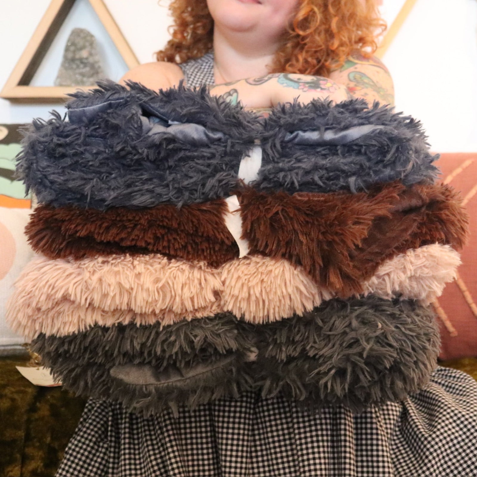 A woman holding all various colors of the Dreamy Faux Fur Throw Blanket.