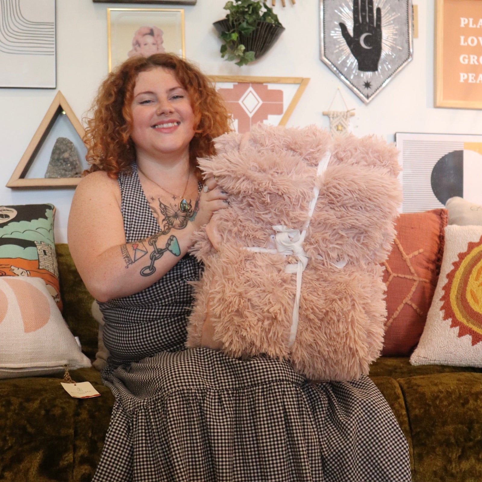 A woman holding the Pink Hero Dreamy Faux Fur Throw Blanket.