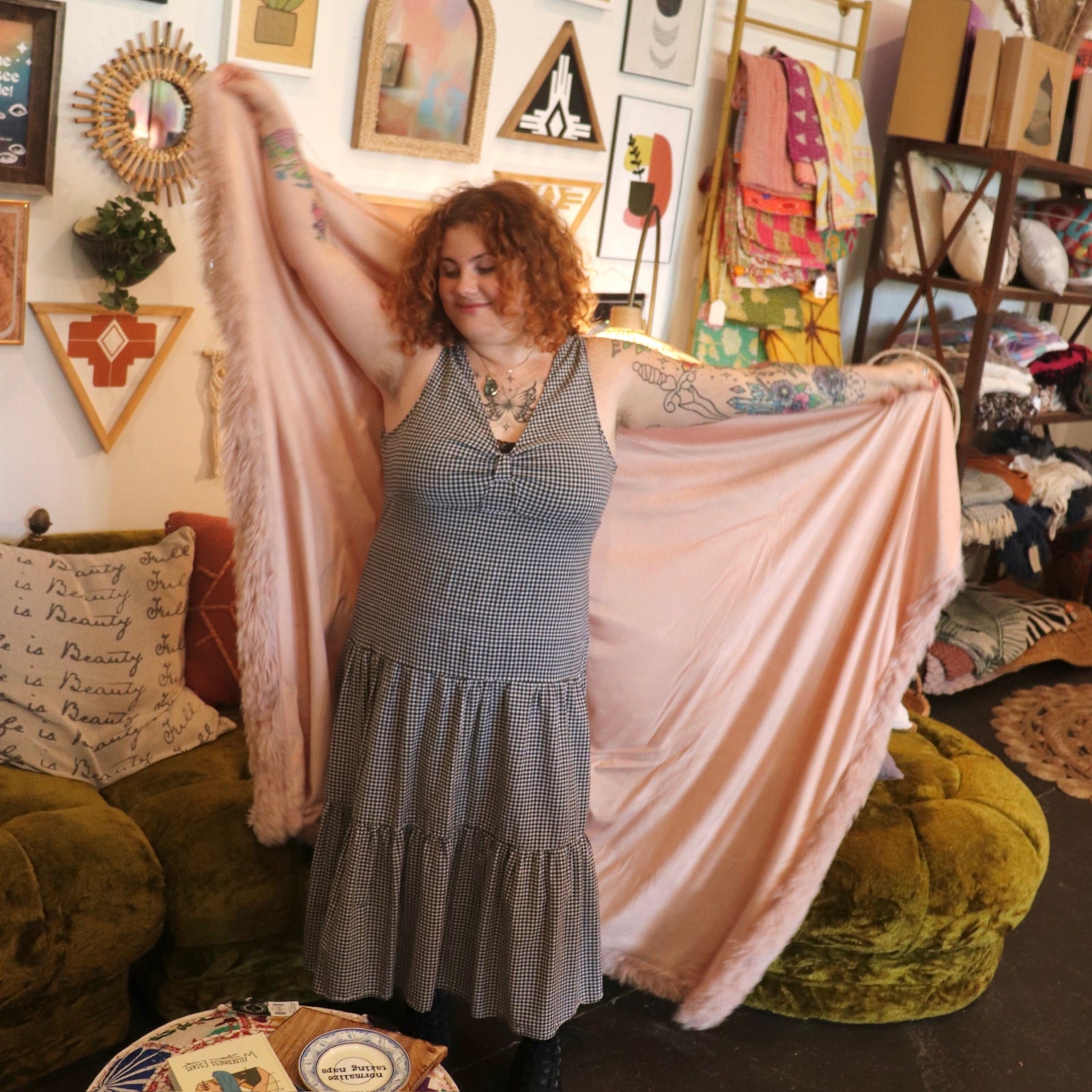 A woman holding the Pink Hero Dreamy Faux Fur Throw Blanket to show off its size.