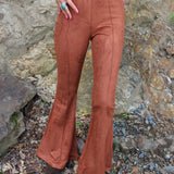 Someone wearing the Pecan Suede Bell Bottoms with an orange, red, and brown top.