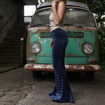 A woman wearing the Navy Velvet Bell Bottom Pants with a cream colored tank all in front of a vintage Volkswagen bus.