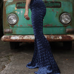 A woman wearing the Navy Velvet Bell Bottom Pants with a cream colored tank all in front of a vintage Volkswagen bus.