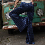 A woman wearing the Navy Velvet Bell Bottom Pants with a cream colored tank all in front of a vintage Volkswagen bus.