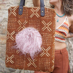 Someone holding the Geometric Rust Mud Cloth Tote with Pink Faux Fur.