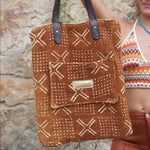 Someone holding the Geometric Rust Mud Cloth Tote with Pink Faux Fur showing off the back pocket.