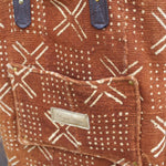 Someone holding the Geometric Rust Mud Cloth Tote with Pink Faux Fur.