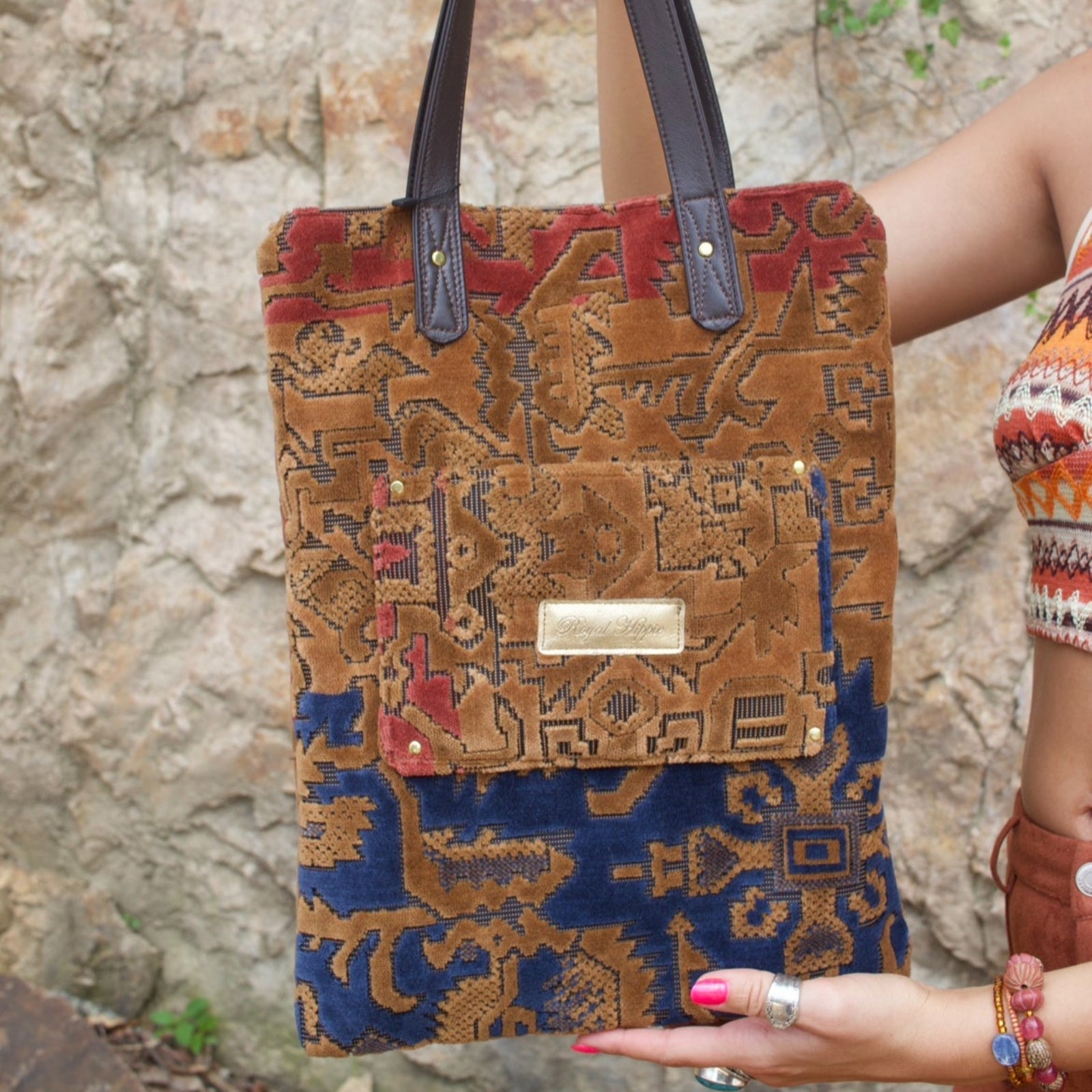 A woman holding the Geometric Velvet Tapestry Tote with Pink Faux Fur showing off the back.