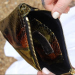 Someone holding the Snake Print Mini Coin Card Pouch open to show the inside.