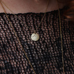 Someone wearing the Capricorn 14k Gold Dipped Nickel-Free Zodiac Necklace with a black net top.