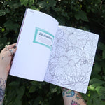 Someone holding the Chappell Roan Coloring & Activity Book open in front of greenery, showing off the pages.