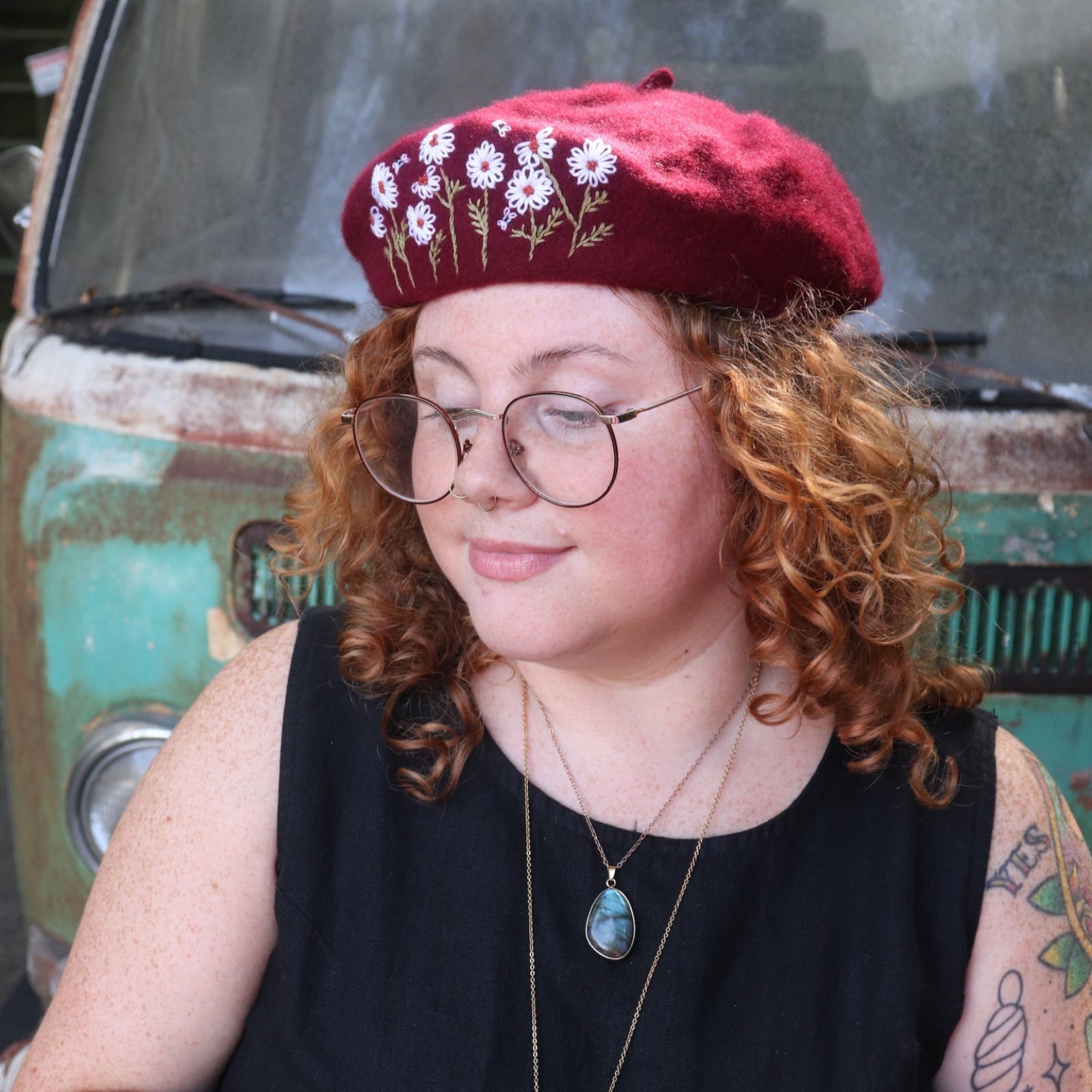A woman wearing the red Hand-Embroidered Floral Soft Beret Stylish Hat with a black tank.