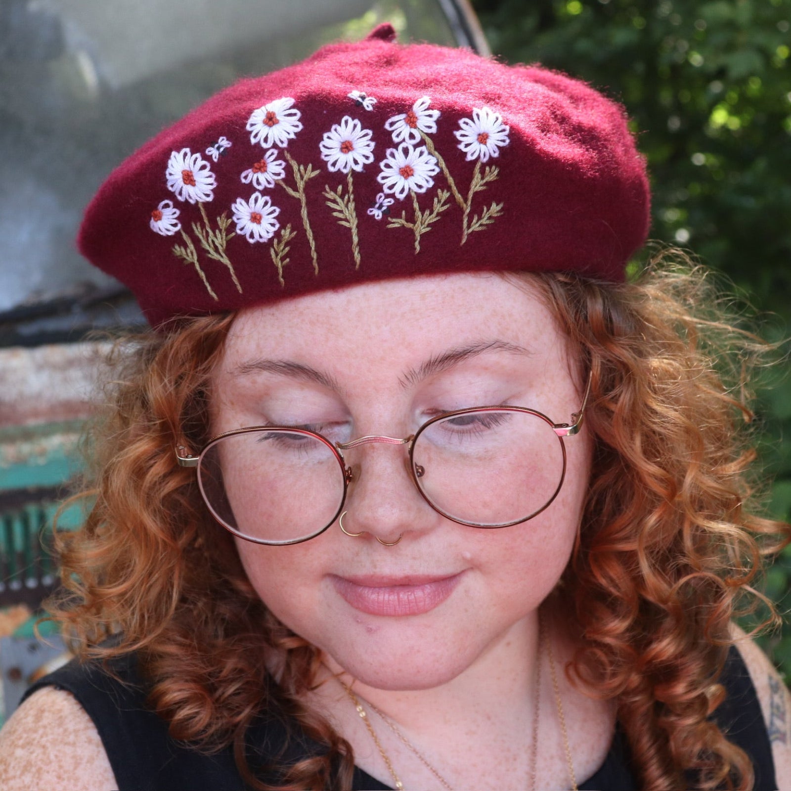 A woman wearing the red Hand-Embroidered Floral Soft Beret Stylish Hat with a black tank.