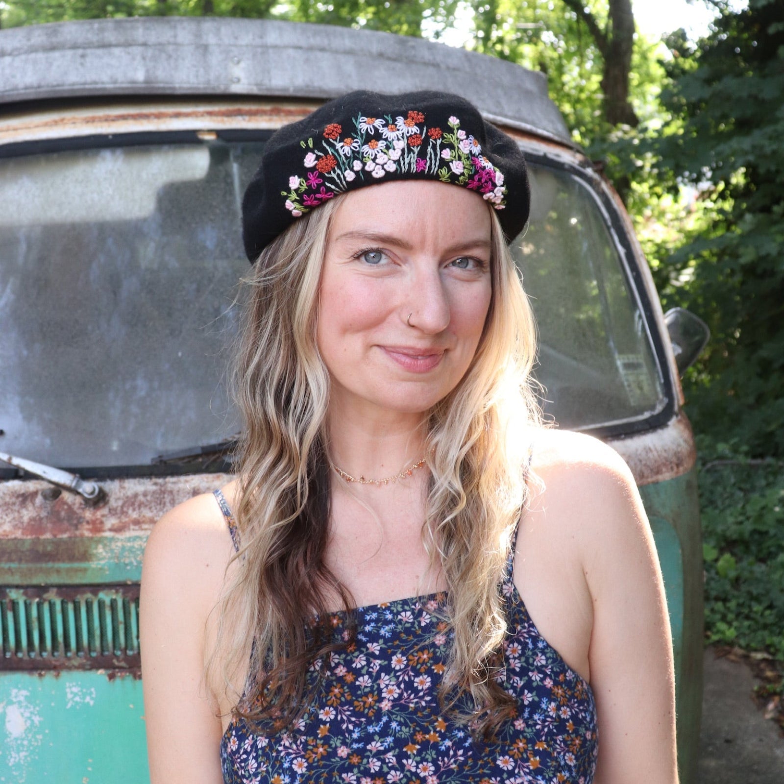 A woman wearing the red Hand-Embroidered Floral Soft Beret Stylish Hat with a black tank.