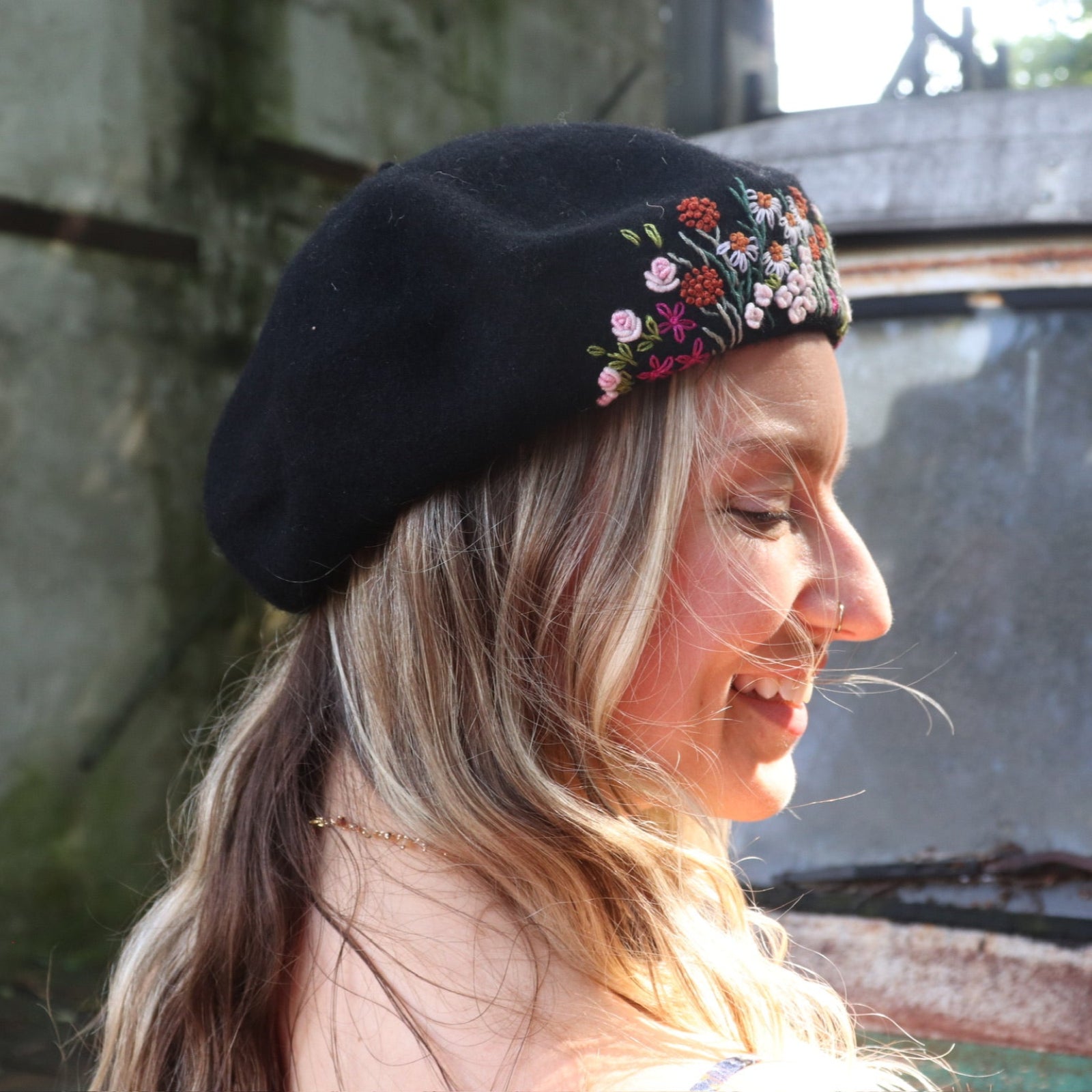 A woman wearing the red Hand-Embroidered Floral Soft Beret Stylish Hat with a black tank.