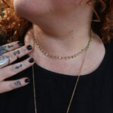 A woman wearing the green Midsummer Gemstone Agate Gold Plated Necklace in front of some greenery.