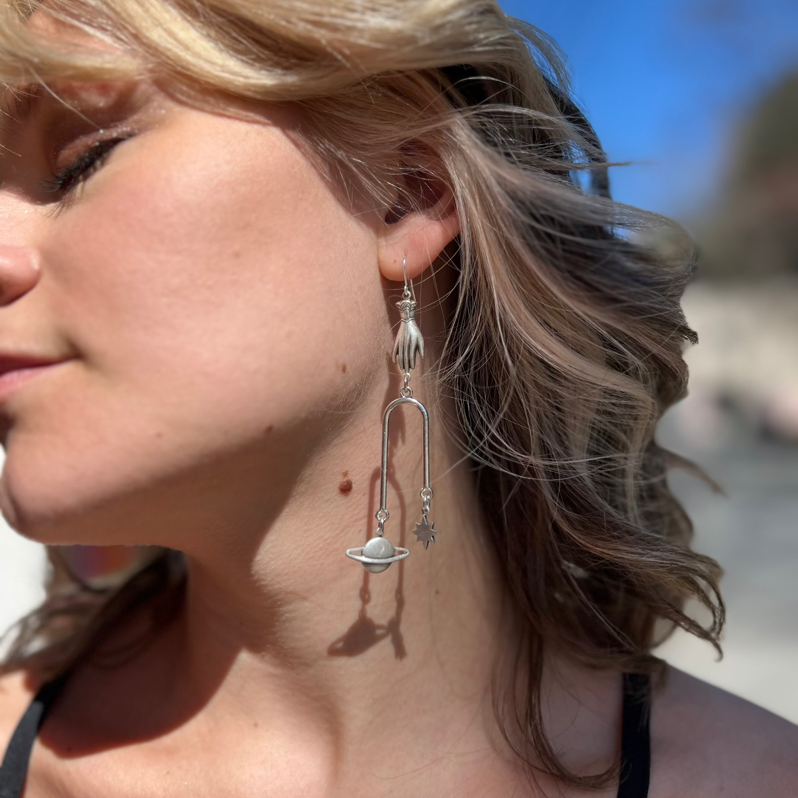 A woman wearing the Silver Magic Mobile 3 inch. Earrings.