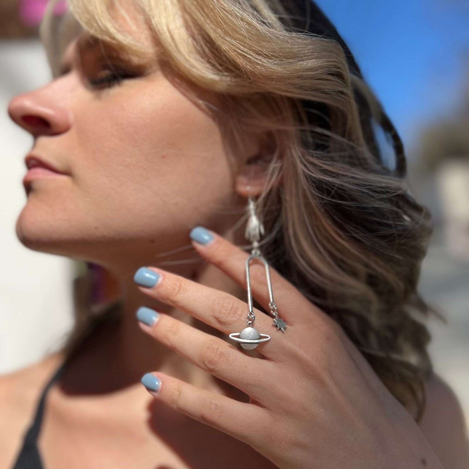 A woman wearing the Silver Magic Mobile 3 inch. Earrings.