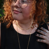 A woman wearing the green Midsummer Gemstone Agate Gold Plated Necklace in front of some greenery.
