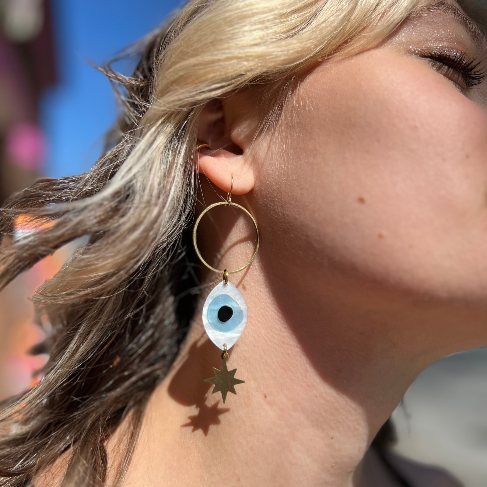 A woman wearing the Brass Future Vision 3 inch. Earrings.