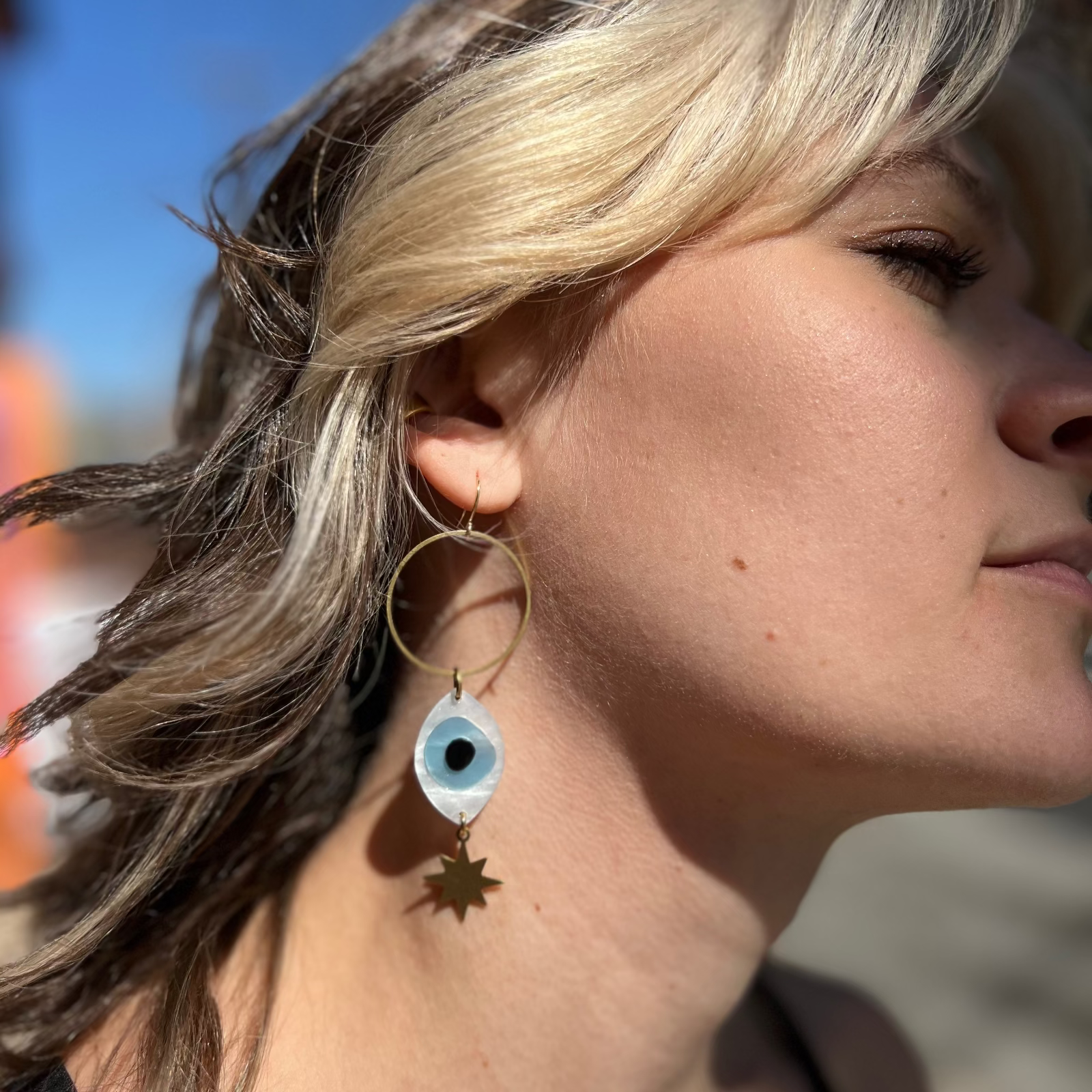 A woman wearing the Brass Future Vision 3 inch. Earrings.