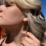 A woman wearing the Brass Star Dancer 2 inch. Earrings.