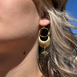 A woman wearing the Brass Star Dancer 2 inch. Earrings.