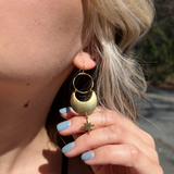 A woman wearing the Brass Star Dancer 2 inch. Earrings.
