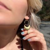 A woman wearing the Brass Star Dancer 2 inch. Earrings.