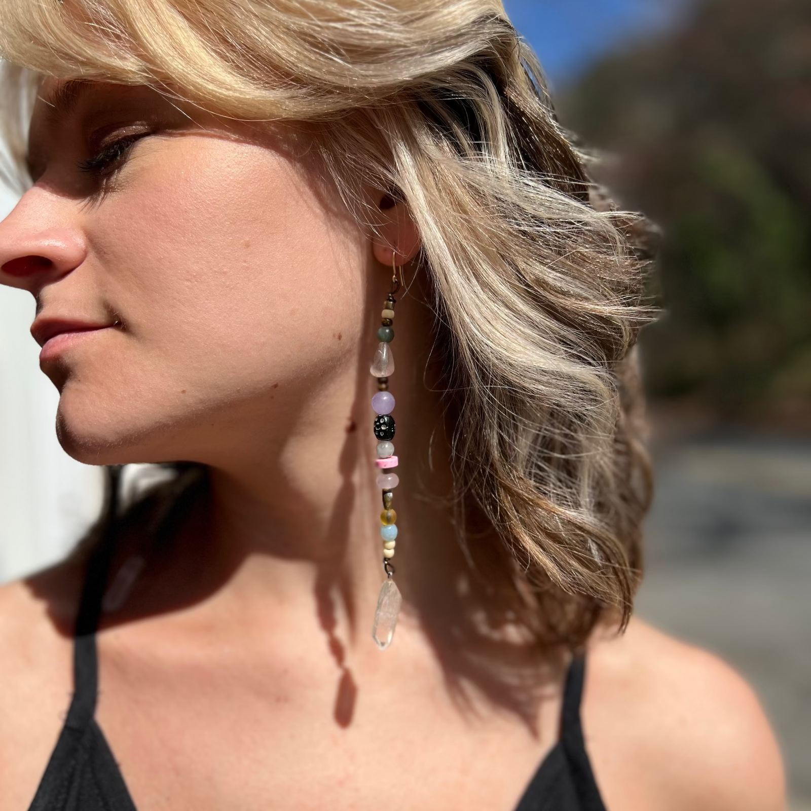A woman wearing the Realm Earrings with a black dress.