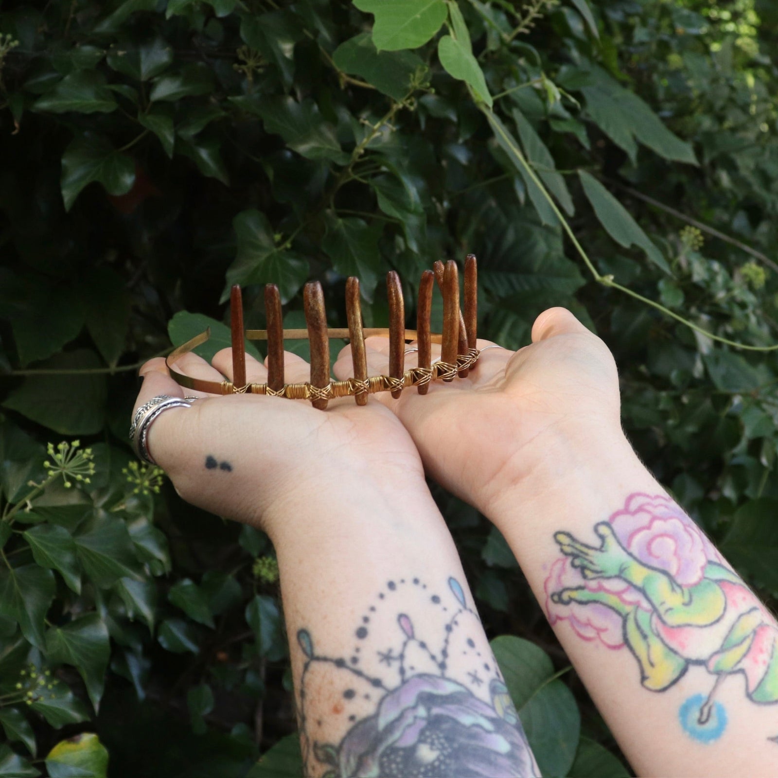 Someone holding the Fairy Crown / Celtic Tiara - Gold Coral in front of greenery.