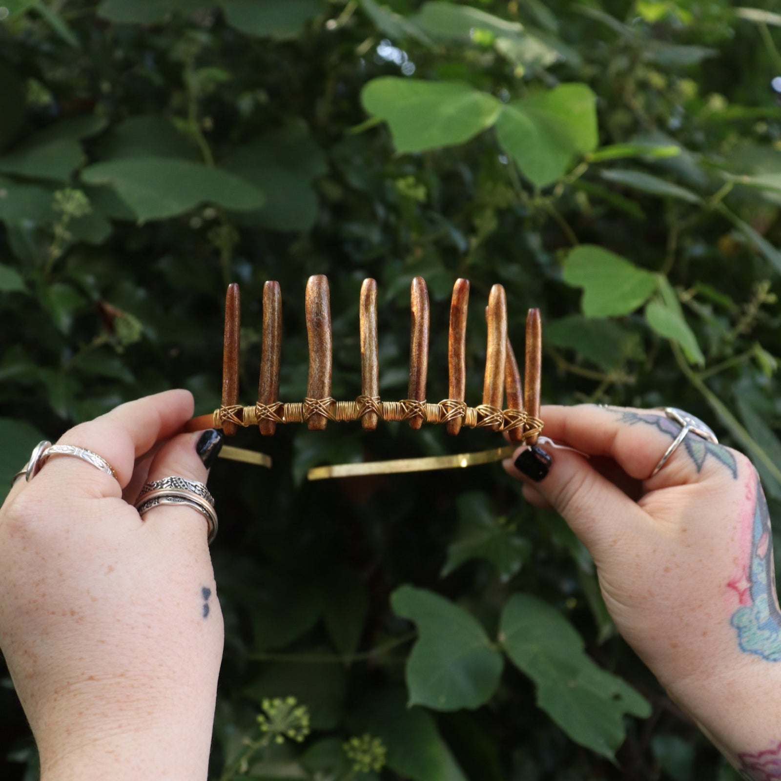 Someone holding the Fairy Crown / Celtic Tiara - Gold Coral in front of greenery.