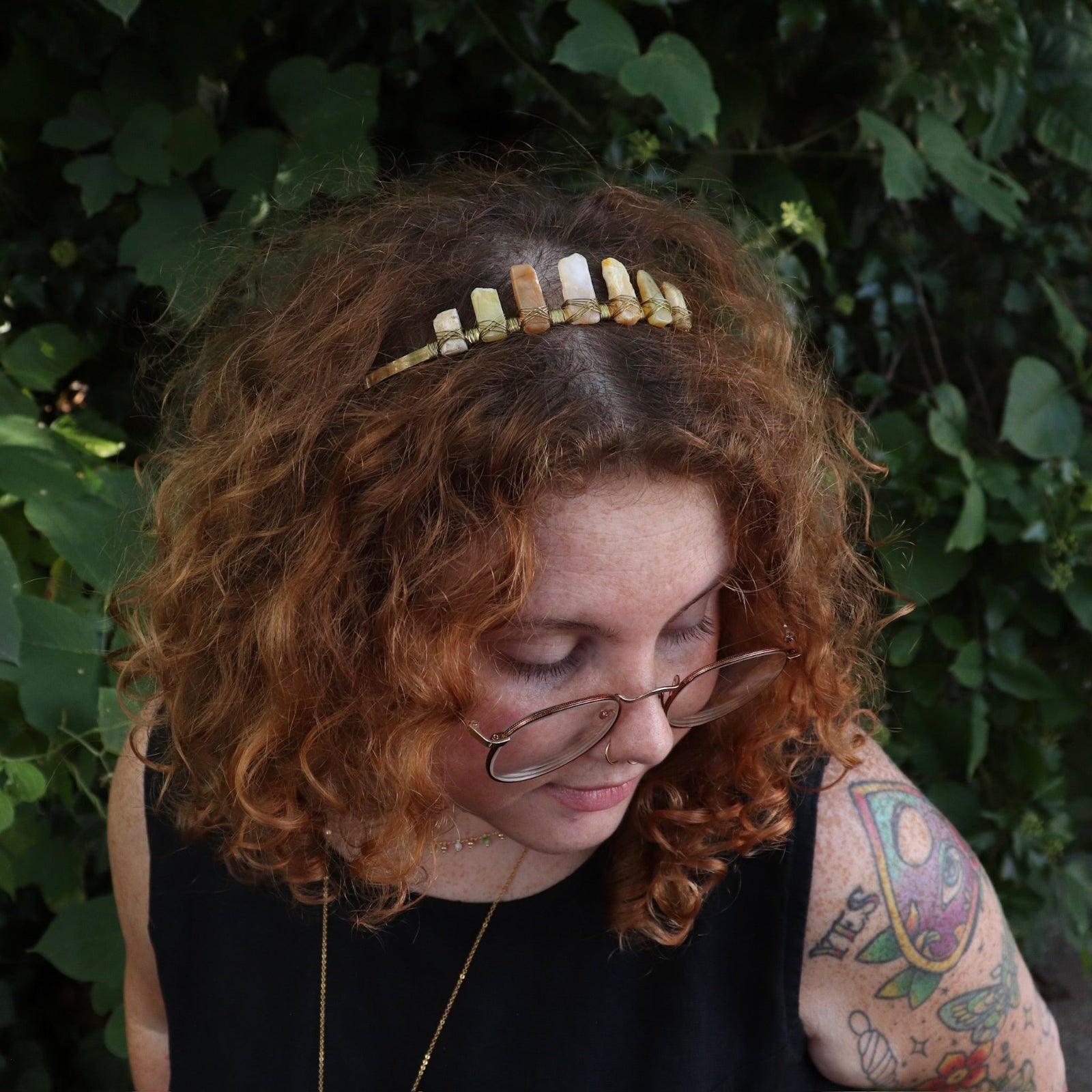 A woman wearing the Fairy Crown / Celtic Tiara - Peruvian Yellow Opal in front of greenery.