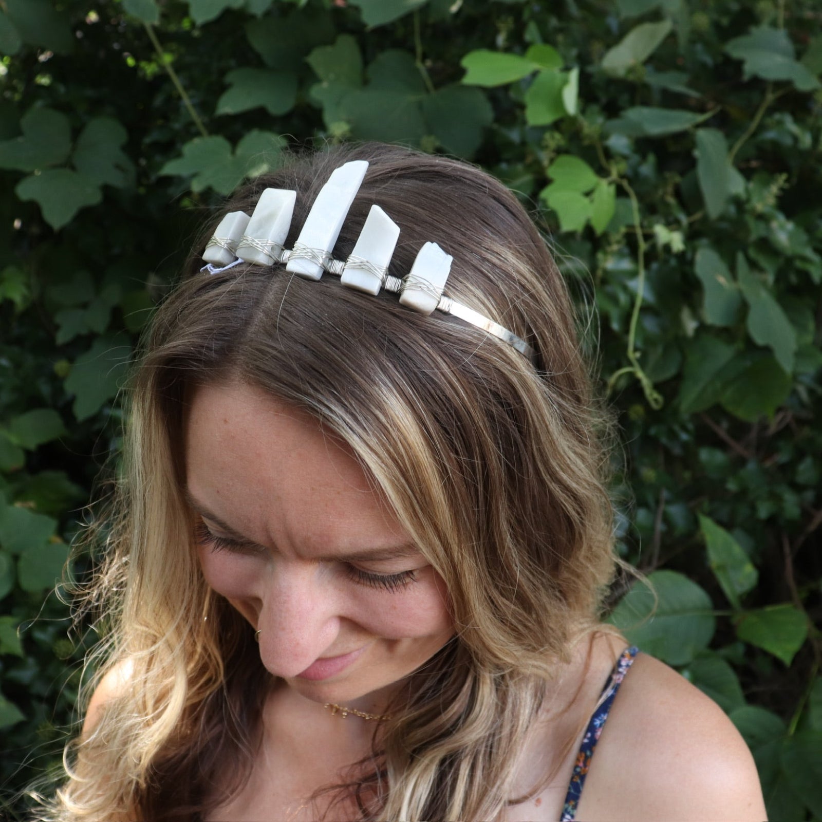 A woman wearing the Fairy Crown / Celtic Tiara - Moonstone - Ice Queen in front of greenery.
