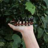 Someone holding the Fairy Crown / Celtic Tiara - Smoky Quartz in front of greenery.