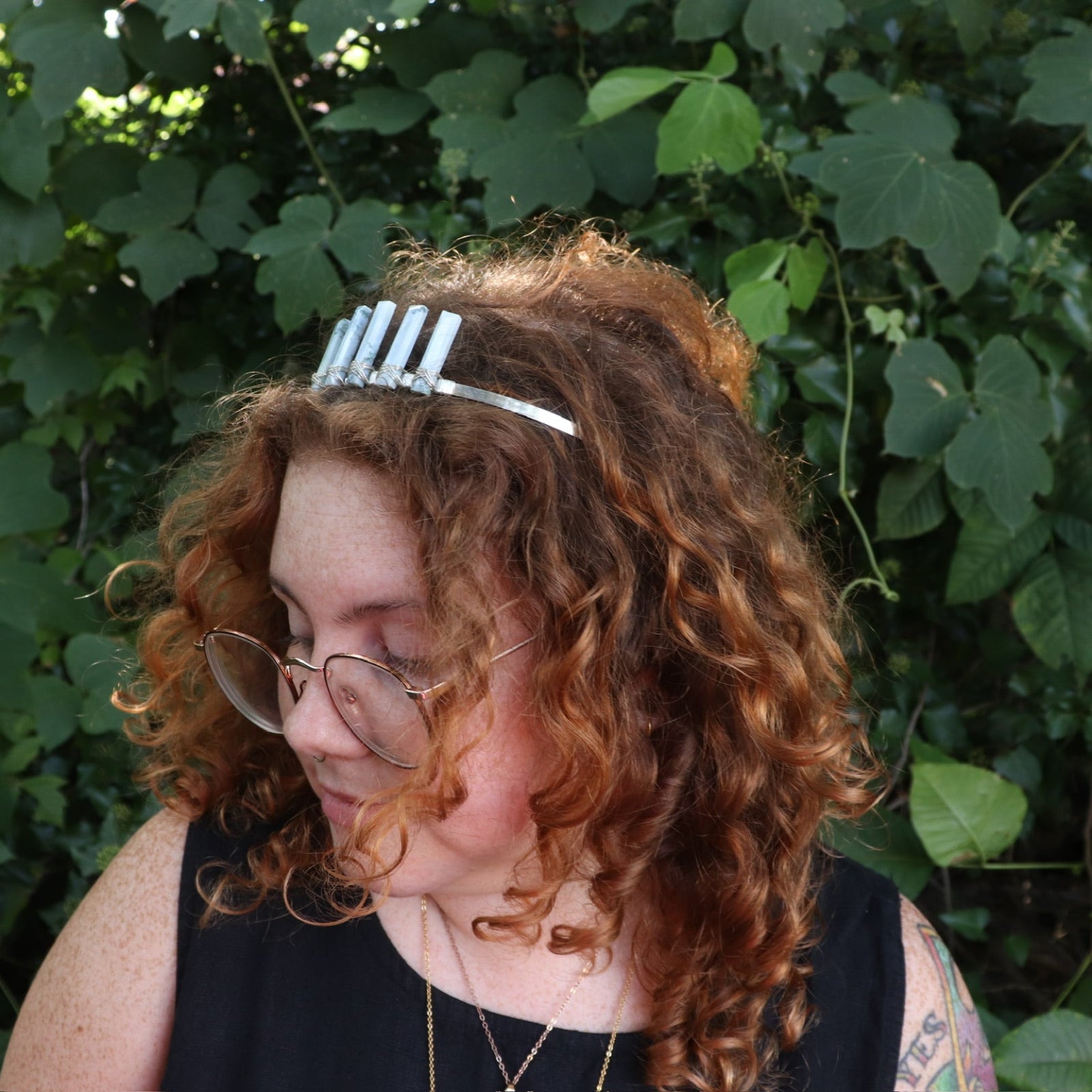 A woman wearing the Fairy Crown / Celtic Tiara - Oregon Blue Opal in front of greenery.