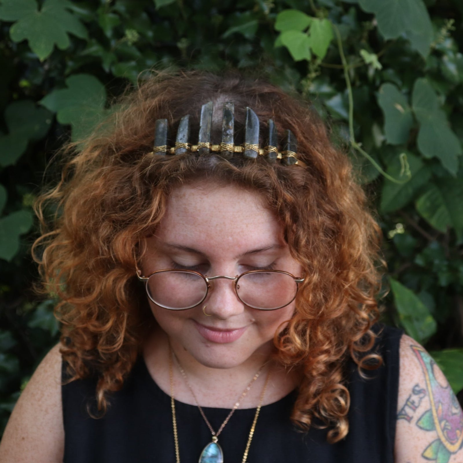 A woman wearing the Fairy Crown / Celtic Tiara - Labradorite in front of greenery.