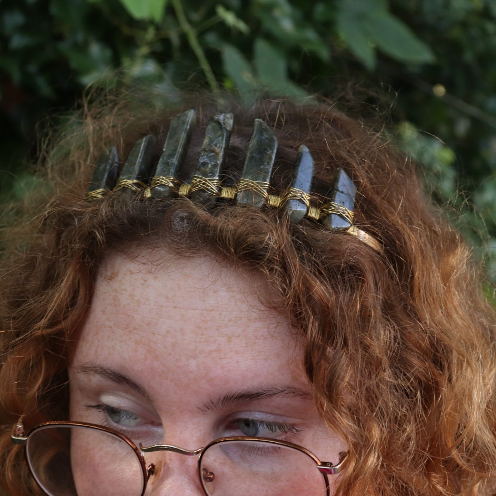 A woman wearing the Fairy Crown / Celtic Tiara - Labradorite in front of greenery.