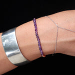 Someone wearing the Dainty Multi-Faceted Amethyst beads + Copper Bracelet in front of a black background.