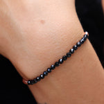 Someone wearing the Dainty Faceted Black Tourmaline beads + Copper Bracelet.