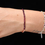 Someone wearing the Dainty and Elegant Multi-Faceted Garnet Beads + Copper Bracelet.