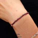 Someone wearing the Dainty and Elegant Multi-Faceted Garnet Beads + Copper Bracelet.