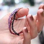 Someone holding all the crystal faceted beads + Copper Bracelets.