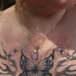 A woman wearing the Mini Rose Quartz Crystal Pendulum Necklace.