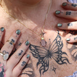 A woman wearing the Mini Rose Quartz Crystal Pendulum Necklace.