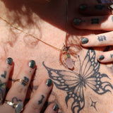 A woman wearing the Mini Rose Quartz Crystal Pendulum Necklace.