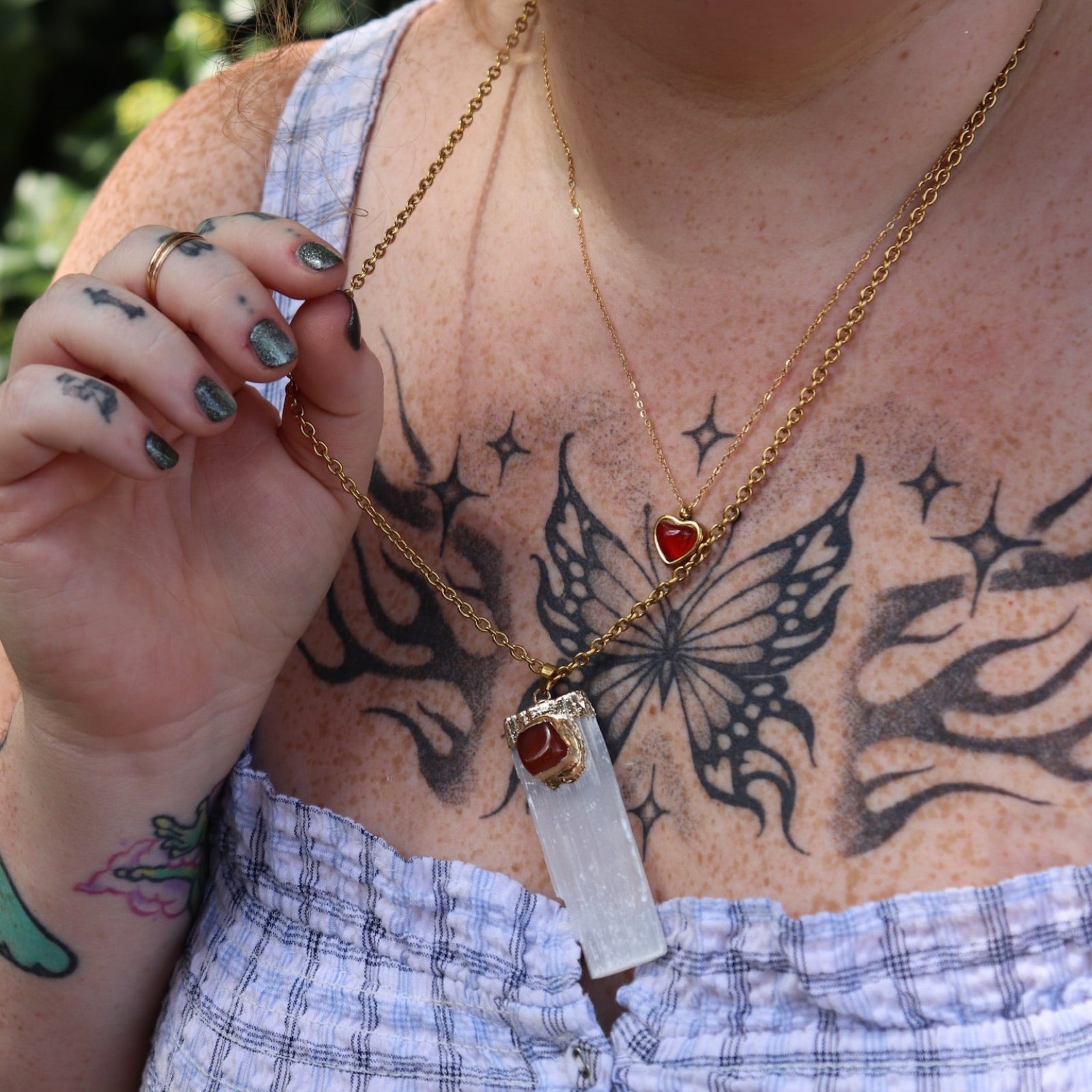A woman wearing the Selenite Carnelian Gold Adjustable Necklace with a blue top.