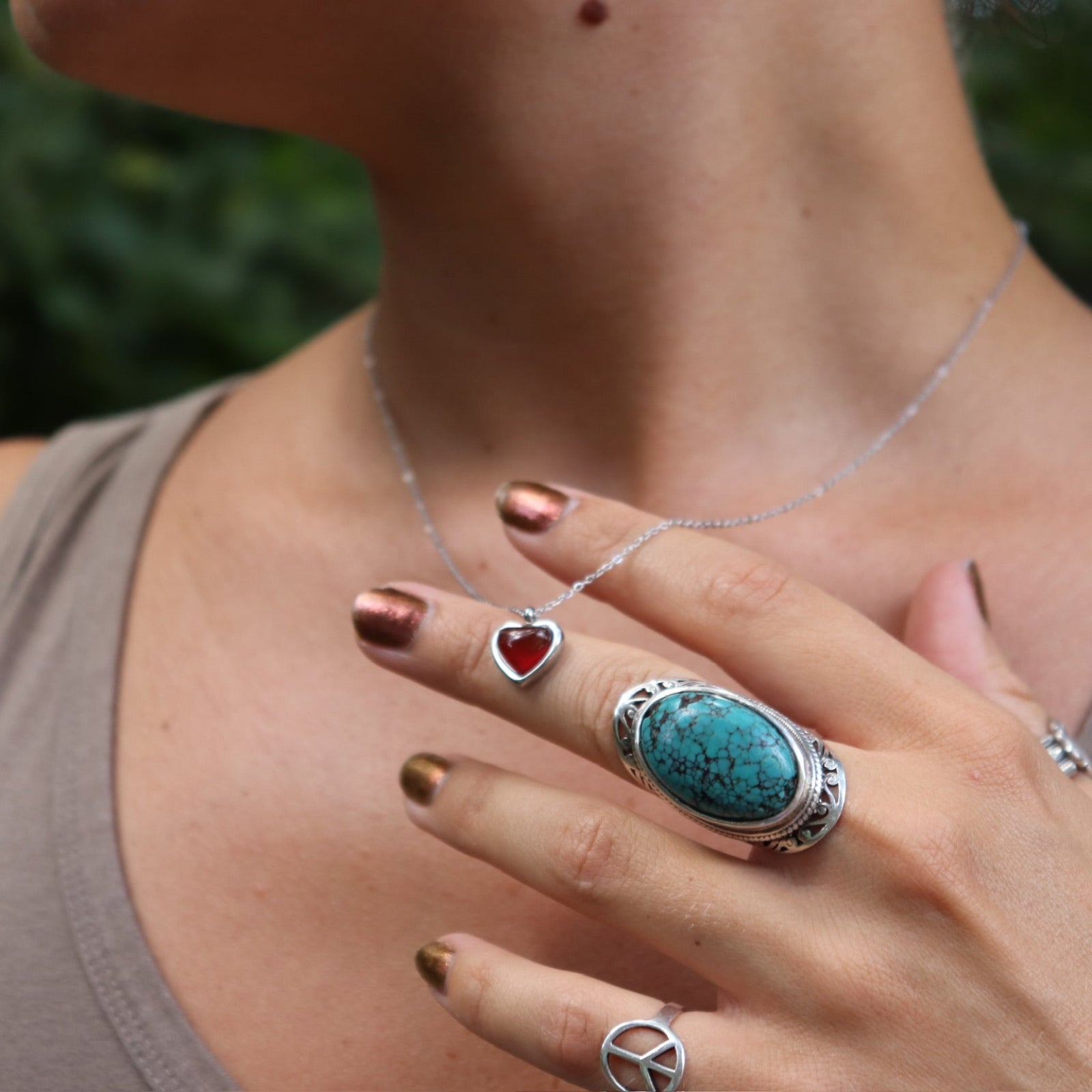 A woman wearing the silver necklace from the Carnelian Earrings & Necklace Gift Jewelry Set.