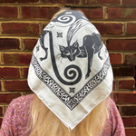 A woman wearing the Screenprinted Chat Noir Cotton Bandana around her head.